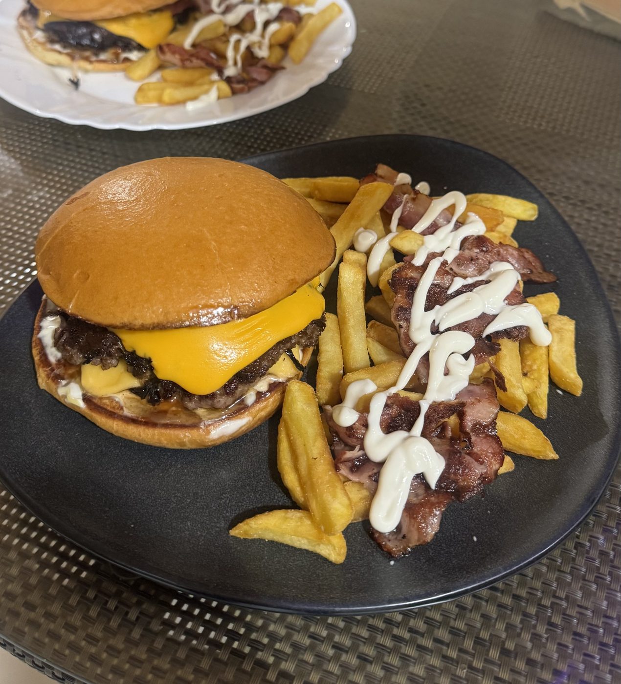 Burger HolyCow cu cheddar și cartofi prăjiți pe farfurie